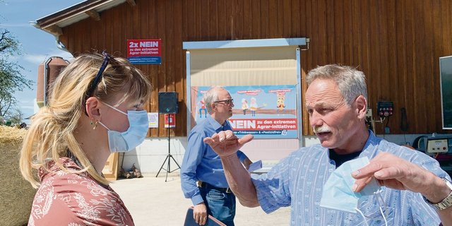 Landwirt Karl Meienberg erklärt einer Journalistin die Folgen der Pflanzenschutz-Initiativen auf seinem Bauernhof. Mitten im Bild Ständerat Peter Hegglin. (Bild Josef Scherer)
