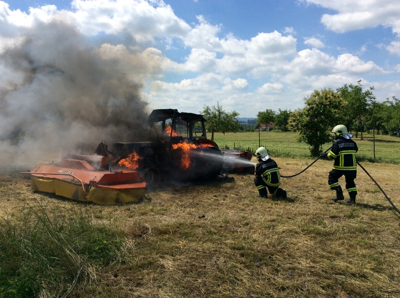 Bei Mäharbeiten geriet der Traktor in Brand: Feuerwehrleute bei den Löscharbeiten. (Bild Kapo TG)