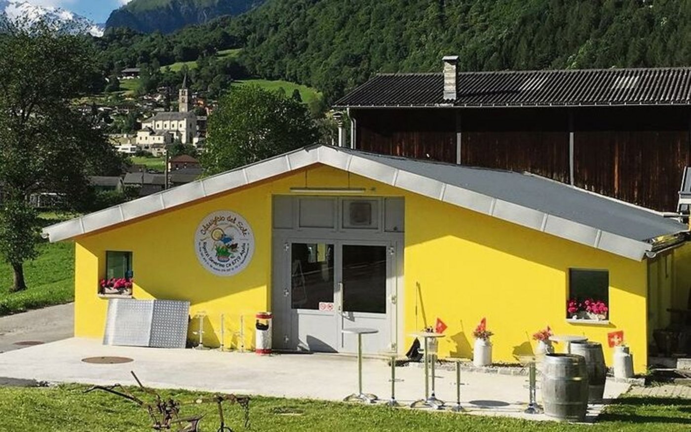 Das Käsereigebäude ist passend zur Tessiner Sonnenstube in leuchtend gelber Farbe gestrichen.  