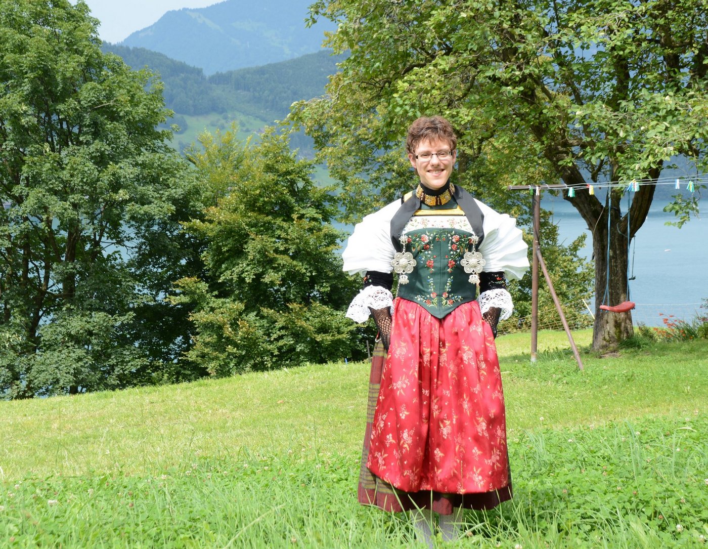 Die leuchtenden Farben von Ruth Buchers Sonntagstracht kommen in der traumhaften Landschaft zwischen See und Bergen ideal zur Geltung. (Bild Andrea Gysin)