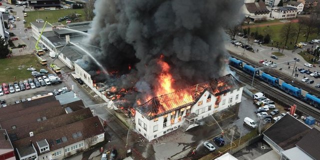 Eine meterhohe, schwarze Rauchwolke steigt aus der Bührer Traktorenfabrik. (Bild Kapo Zürich)