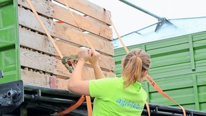 Beim Niederzurren wi Beim Niederzurren wird die Ladung mit Kraft auf die Ladefläche gepresst, sodass diese nicht verrutschen kann. Sofern die Anhängerwand die Kraft aufnehmen kann, kann hier auch mit dem Formschluss gearbeitet werden.