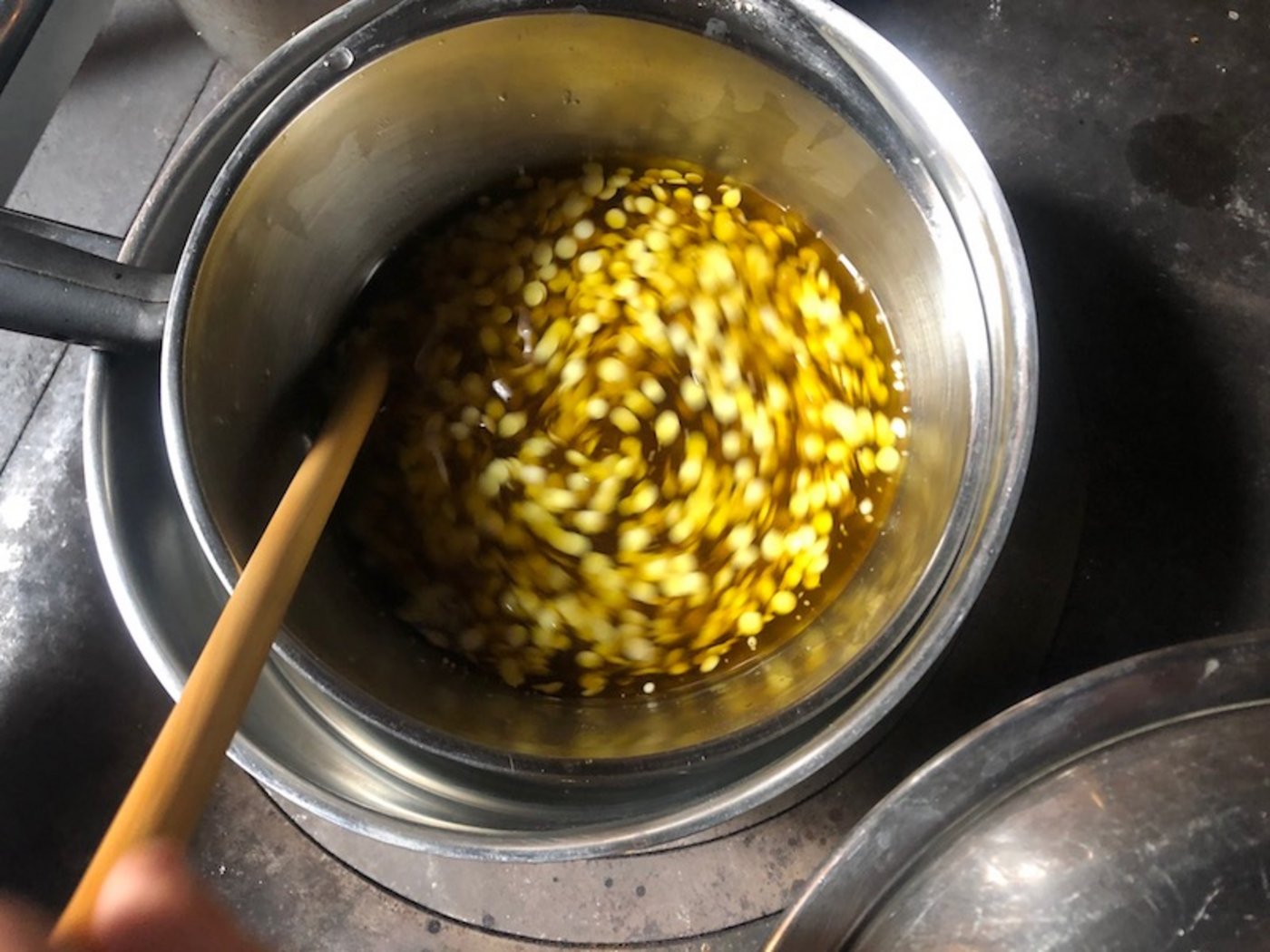 Salbenherstellung: Einrühren des Bienenwachs ins Pflanzenöl.