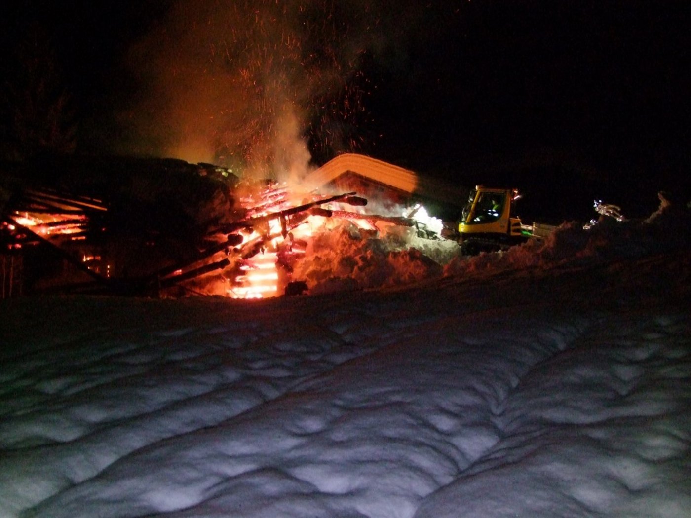 Ungewöhnliche Löschmethode: Der Pistenbully überhäuft den Stall mit Schnee. (Bild Kapo GR)