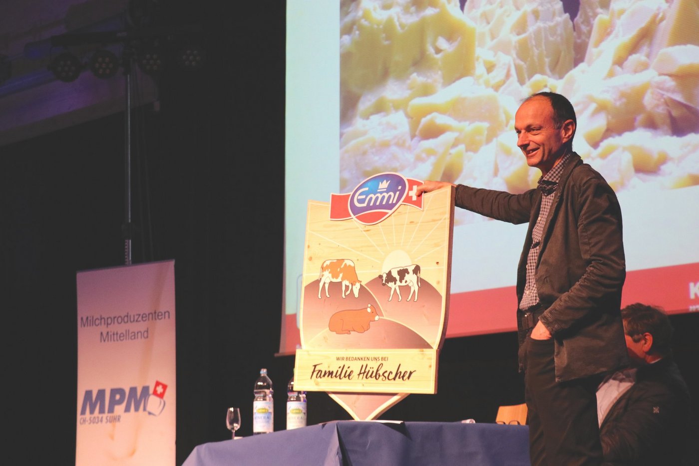 Milchproduzententag in Brunegg: Marco Genoni, MPM-Geschäftsführer, mit einem Prototyp der Tafel, die als Endprodukt gemäss Reto Hübscher noch etwas milchbetonter und grüner werden soll. (Bild Ruth Aerni)