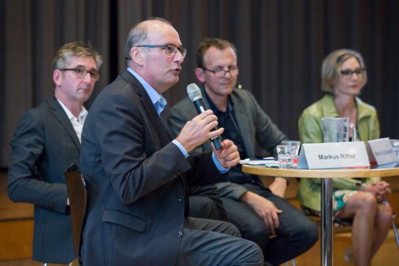 Markus Ritter (am Mikrofon), Markus Schlagenhof, Adrian Krebs (Moderator), Maya Graf und Elisabeth Bürgi Bonanomi (nicht im Bild) diskutieren über die Frage, wie die Fair-Food-Initiative mit internationalem Handelsrecht vereinbar ist. (Bild zVg)