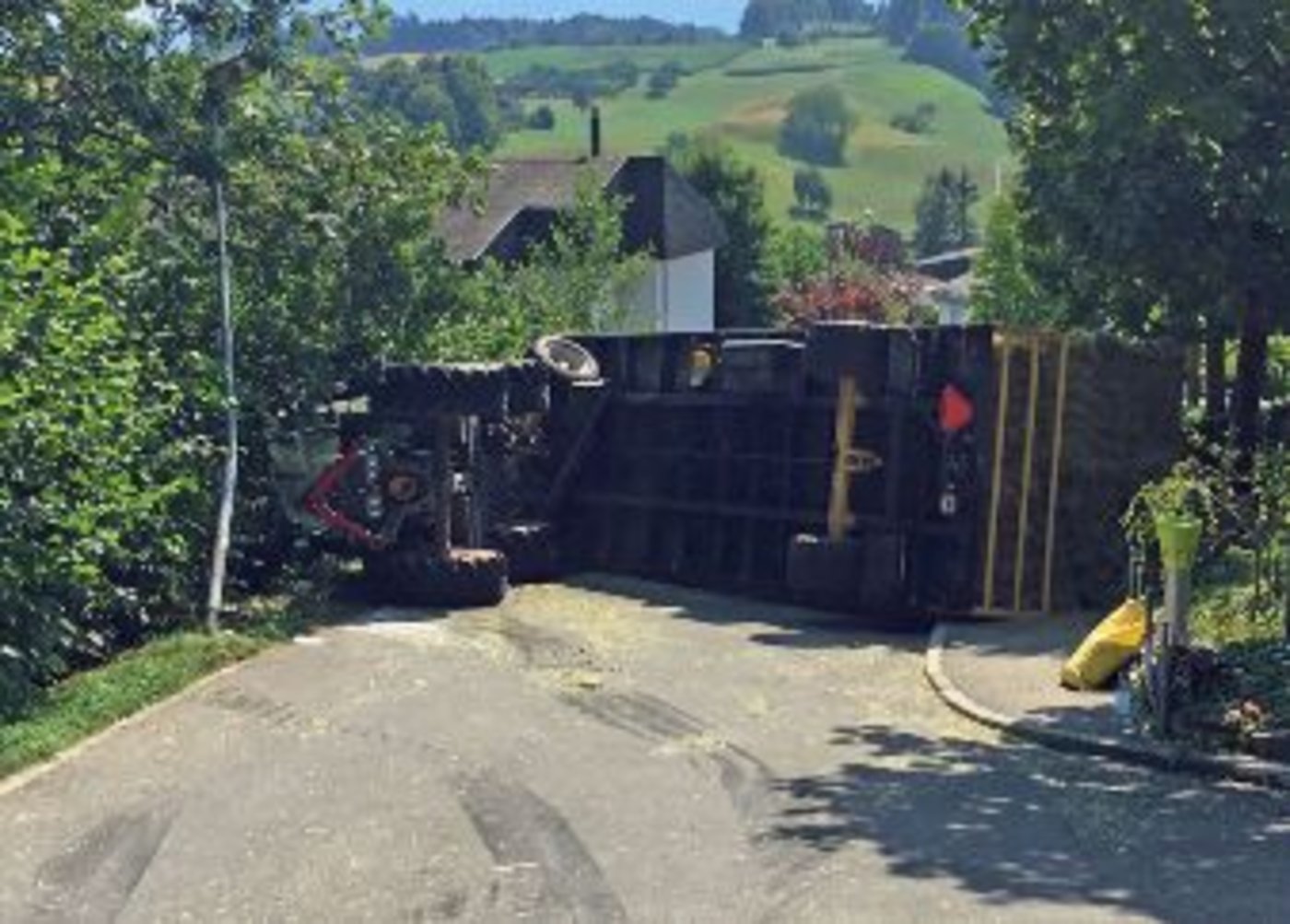 Der Traktor und der mit Heuballen beladene Anhänger kippten auf die Seite. (Bilder Luzerner Polizei)